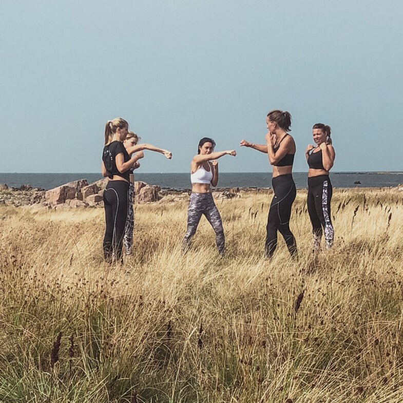 Grupp med kvinnor som tränar på strandäng